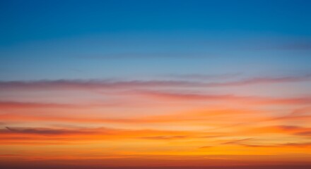 Obraz premium A beautiful, vibrant sunset sky with clouds in a smooth gradient of orange, pink, and blue