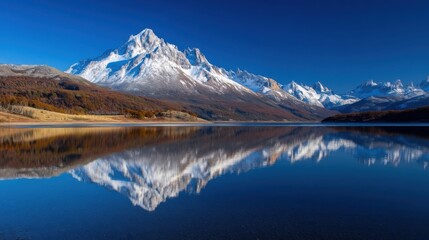 Obraz premium Expansive mountainous landscape with snow capped peaks under clear blue sky,