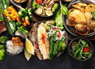 Table scene of various delicious foods. Healthy, family dinner.