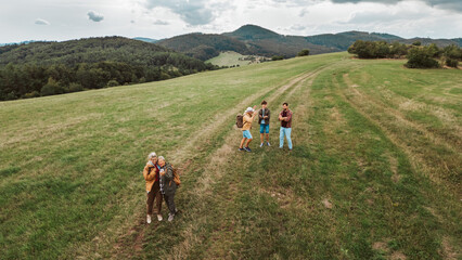 Obraz premium Aerial view of multigenerational family on hiking trip in nature.