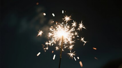 A sparkler blooms with bright light against a dark background, full of a dreamy feeling.