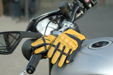 Motorsport. A sports bike.Steering control. A close-up of the gas tank. There are leather gloves of a motorcyclist on the gas tank.