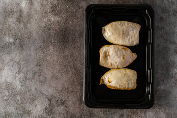 frozen squid stuffed with rice on a dark background