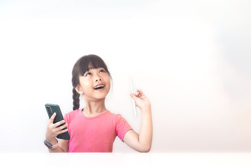Fototapeta premium A girl is using a smartphone and a pen looking at the blank space and thinking about something on a white background for text.
