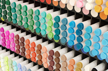 A variety of markers in various colors on a display of products for artists