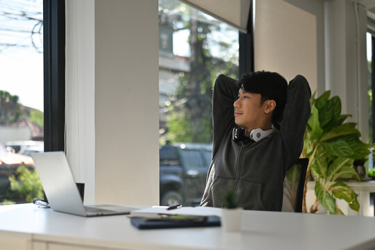 An Asian Man Relaxing at Desk During Remote Work Break, Work-Life Balance & Digital Wellness