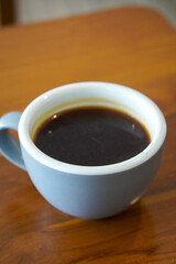 Hot Americano Coffee, captured on September 1, 2025. Steaming black coffee served in white ceramic cup on wooden table, cozy minimalist style, perfect for café, breakfast, and lifestyle themes