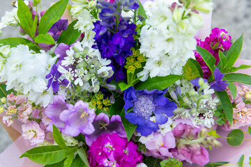 Flower bouquet made of mixed spring flowers. Beautiful pink, white and blue fresh flowers arrangement. Birthday bouquet with larkspur and matthiola stock.