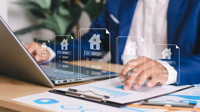 Businessman using digital tablet with virtual property documents and checklist icons. Concept of real estate technology, online mortgage, smart contract, and house investment.