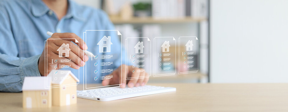 Businessman using digital tablet with virtual property documents and checklist icons. Concept of real estate technology, online mortgage, smart contract, and house investment.