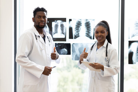 Collaborative team of male and female medical professionals analyzing diagnostic x-rays in clinical environment. - Powered by Adobe