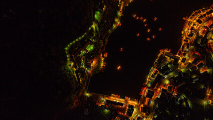 At dusk the reflections of the lights from the village the lake in Chinese-style structures with...