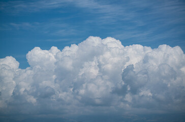 Fluffy White Clouds Against a Bright Blue Sky with Soft Wispy Atmosphere