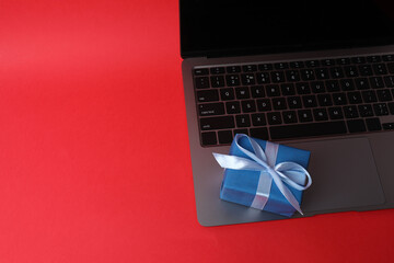 gift boxes, laptop on a red background

