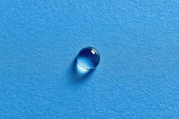 Single water droplet on blue textured surface
