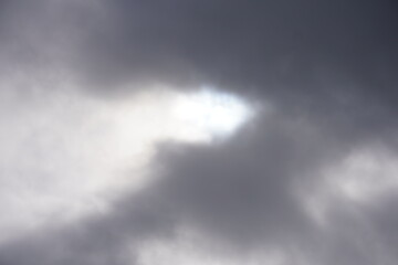 Dramatic sky with sun rays through dark storm clouds