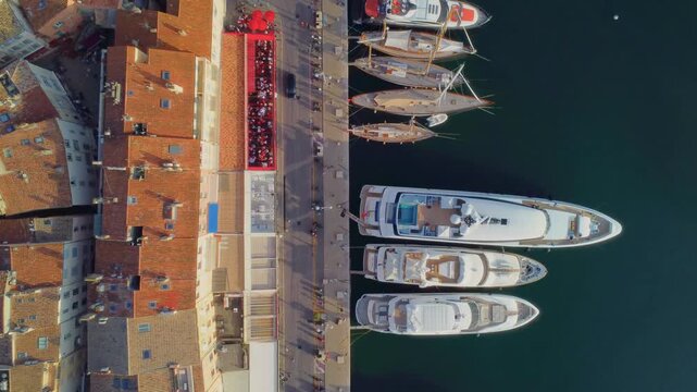 aerial perspective captures the vibrant Port de Saint Tropez on the French Riviera, showcasing an array of luxurious yachts, prominently featuring sleek VanDutch vessels, alongside the picturesque har