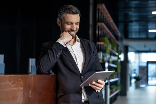 Man reading something online on a tablet and looking interested