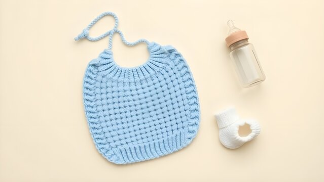 A soft beige backdrop cradles baby essentials—a knitted blue bib, tan-capped bottle, and white pacifier—gentle care in every detail.