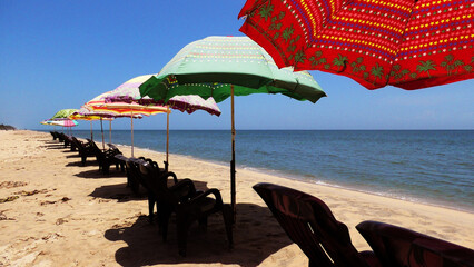 Colorful umbrellas and chairs set up for tourists at Marari Beach at Alappuzha, Kerala, India