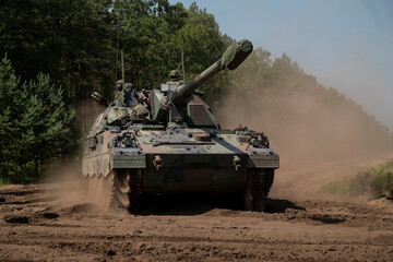 Self-propelled howitzer photographed from frontal angle showing dust and operational capability