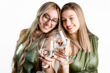 Two friends smiling and holding wine glasses, festive portrait on white