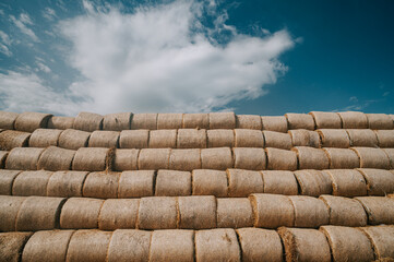 A pyramid of hay bales creates a striking visual structure that can represent farm efficiency or serve as an artistic digital backdrop.