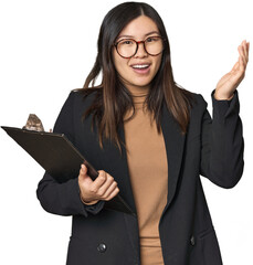 Chinese businesswoman holding inventory list receiving a pleasant surprise, excited and raising...