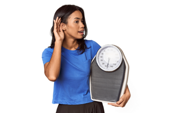 Filipino woman with scale in studio trying to listening a gossip.