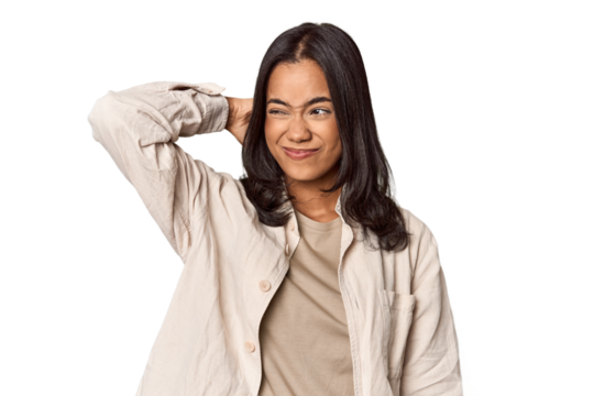 Portrait of a young Filipino woman touching back of head, thinking and making a choice.