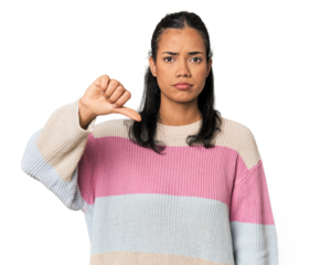 Young Filipina woman showing a dislike gesture, thumbs down. Disagreement concept.