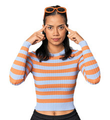 Young Filipino woman in studio focused on a task, keeping forefingers pointing head.