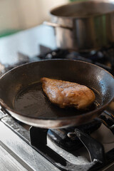Close-up of meat cooking and searing in professional kitchen pan with oil