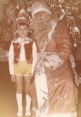 Six-year-old boy in Pinocchio costume at Christmas carnival near Christmas tree in school, captured in film photography style from early 1990s in Ukraine