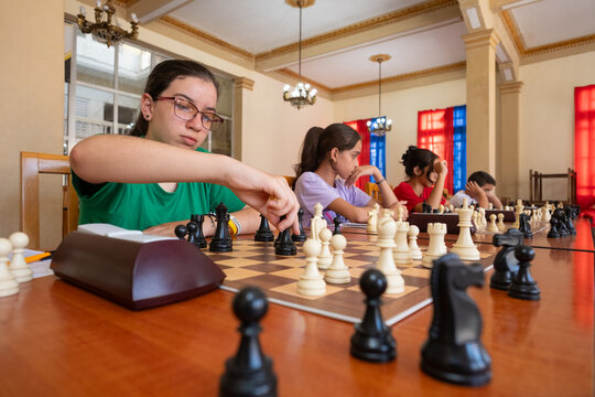 Children playing simultaneous chess in a classroom setting