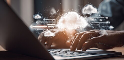 Close-up of hands typing on a laptop with cloud computing graphics overlay