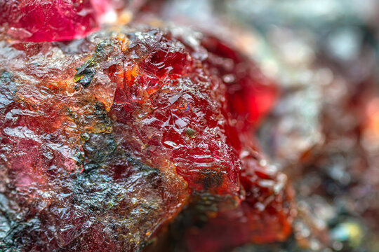 Closeup rare natural rough Eudialyte gemstone crystal (red - pink), a radioactive cyclosilicate mineral containing zirconium and rare earth elements (REE)(selective focus)