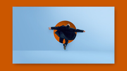 Digital artwork. Businessman jumping through round doorway on blue wall with open arms and dramatic fashion expression. Concept of dramatic freedom, surreal fashion, bold expression, web design 2.0.