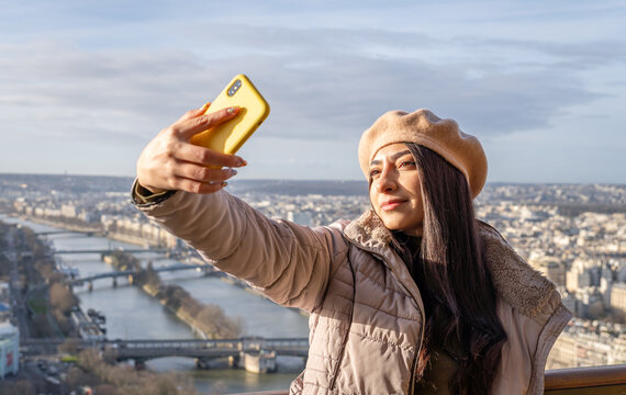 Young woman takes a selfie at the Eiffel Tower