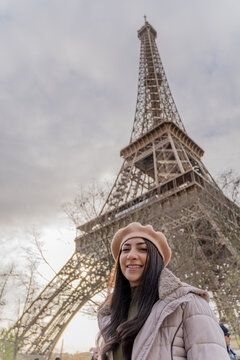 Woman smiling in front of the Eiffel Tower on a winter morning