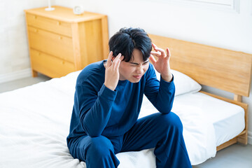 頭を抑える男性