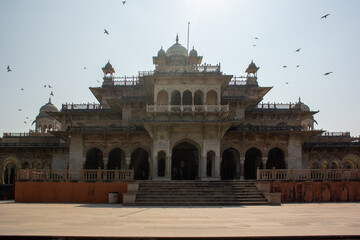 The Albert Hall Museum in Jaipur, India, an ancient architectural marvel, stands majestically under a clear sky with birds flying. Ideal for travel, cultural, or historical documentation, it showcases