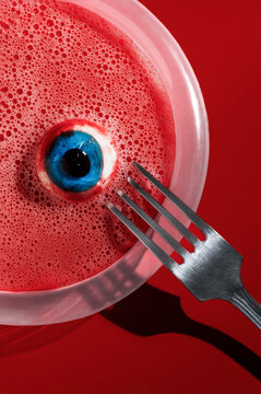 Spooky Halloween eyeball prop in red liquid with fork
