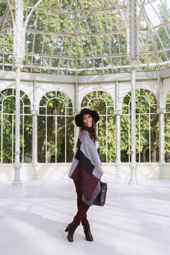 Woman smiling in a sunlit glass atrium