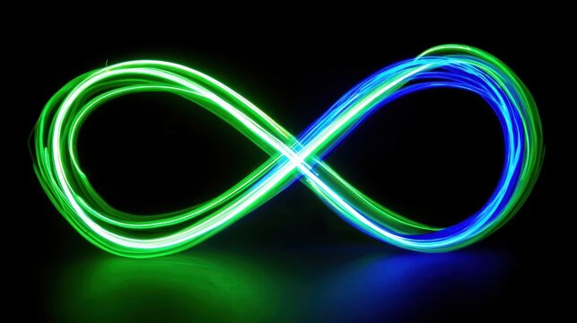 Green and blue light trails forming infinity symbol through light painting technique, creating ethereal pattern revealing continuous flow against dark reflective surface