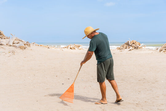Man cleaning litter on Punta Astilleros Beach in Colombia