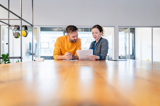 Colleagues collaborating at office table during business meeting