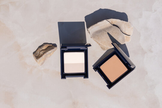 Compact makeup products with stones in natural setting