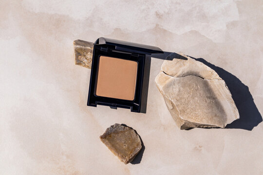 Compact makeup products with stones in natural setting