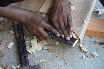 Woodworker Carving with Chisel and Hammer